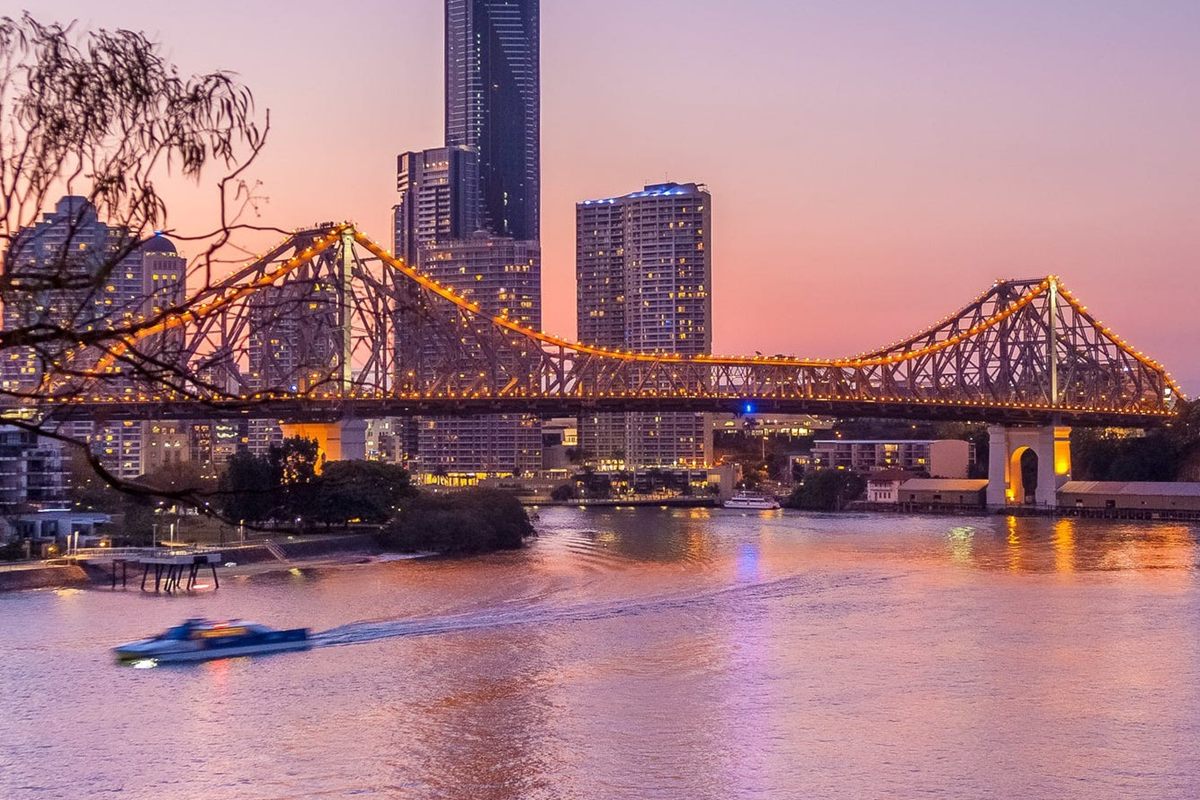 The Story Bridge lit up at dusk over the Brisbane River
